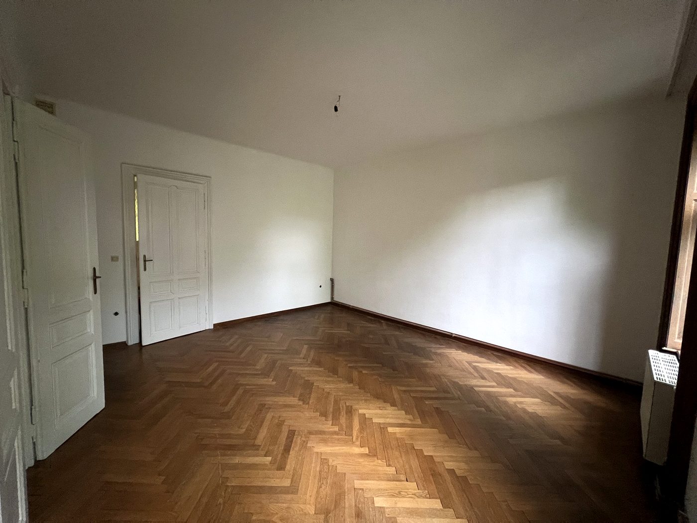 Leeres Zimmer mit zwei Türen und Parkett