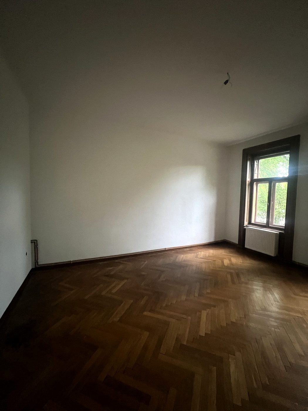 Leeres Zimmer mit einem Fenster und Heizkörper