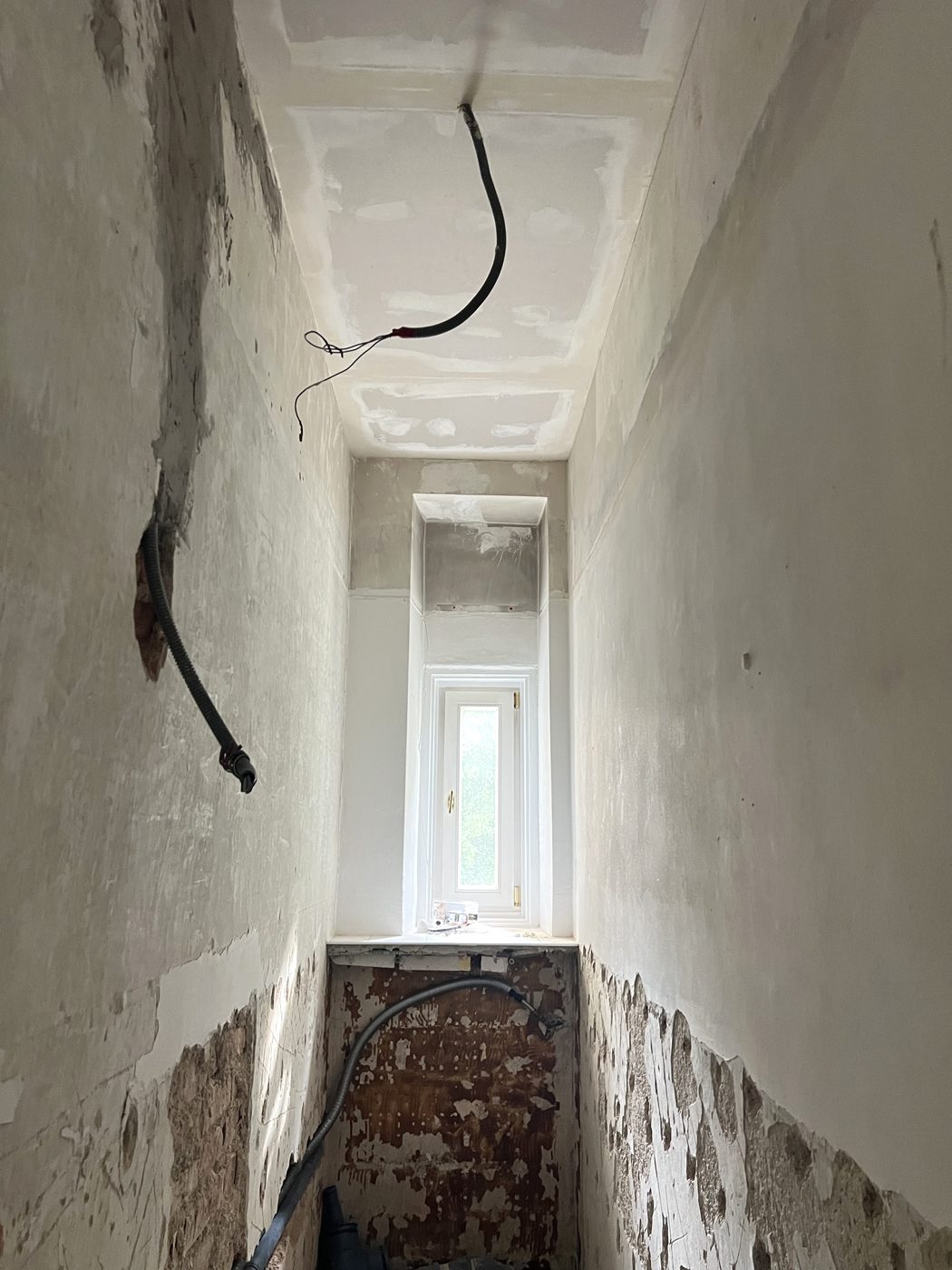 WC-Raum von unten fotografiert: Decke, Wände und Fenster